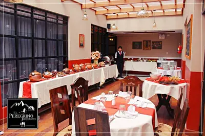 a man is standing in a restaurant with tables at El Peregrino Apart Hotel in Abancay