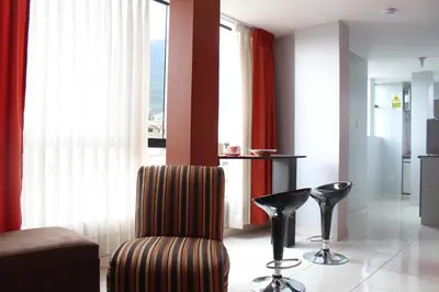 a living room with a chair and two stools at El Peregrino Apart Hotel in Abancay
