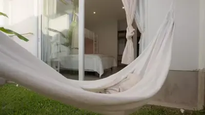 a hammock in a room with a bedroom at Relájate en piscina-spa, terraza BBQ y AC Paracas in Paracas