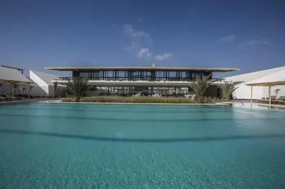 a large pool of blue water in front of a building at Relájate en piscina-spa, terraza BBQ y AC Paracas in Paracas