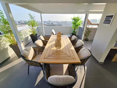 a wooden table and chairs in a room with a balcony at Penthouse Luxe private Jacuzzi King AC in Lima