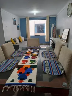 a living room with a table with colorful carpets on it at Lucia's apartmens in Cusco