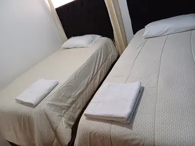two beds sitting next to each other in a room at Lucia's apartmens in Cusco