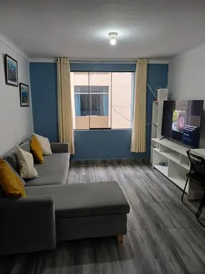 a living room with a couch and a tv at Lucia's apartmens in Cusco