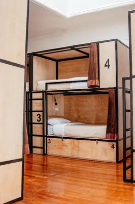 three bunk beds in a room with wooden floors at Black Llama Hostel Cusco in Cusco