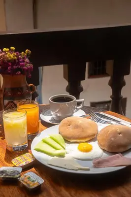 a plate of food with eggs and apples on a table at Black Llama Hostel Cusco in Cusco