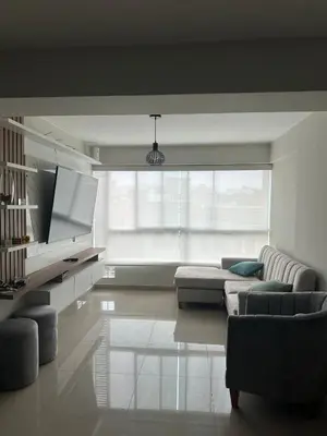 a living room with a couch and a tv at Apartamento 3 habitaciones, Santa Beatriz - Perú in Lima