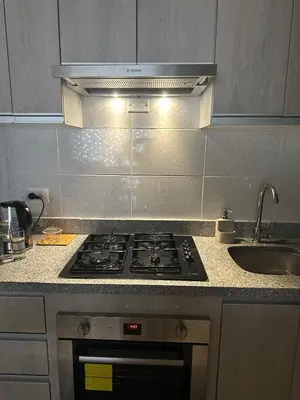 a kitchen with a stove and a sink at Apartamento 3 habitaciones, Santa Beatriz - Perú in Lima