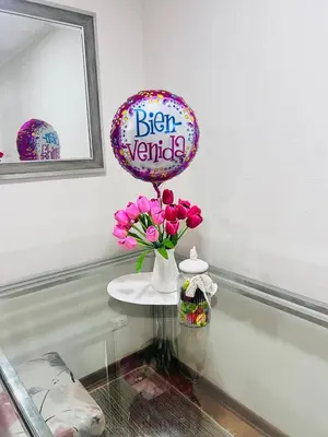a vase of pink flowers on a table with a balloon at Pacific Apartamento Surco in Lima