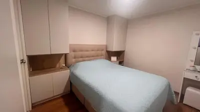 a small bedroom with a bed and white cabinets at Pacific Apartamento Surco in Lima