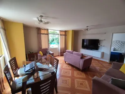 a living room with a couch and a table and chairs at SUMAQ PUNUY HOSTEL - Lima Airport in Lima