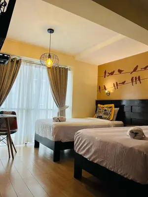 a bedroom with two beds and a window with birds on the wall at LOS ARCES HOTEL in Lima