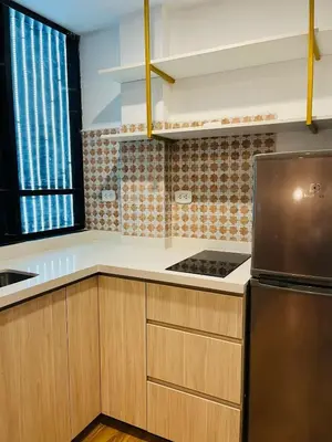 a kitchen with wooden cabinets and a stainless steel refrigerator at LOS ARCES HOTEL in Lima