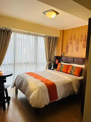 a bedroom with a bed with orange pillows and a window at LOS ARCES HOTEL in Lima