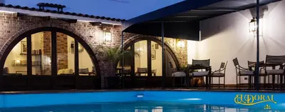 a swimming pool in front of a building with chairs at Apart Hotel El Doral in Lima