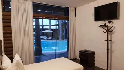 a bedroom with a sliding glass door to a pool at HOTEL RUSTICA PACHACAMAC in Lima