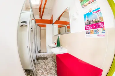 a bathroom with a red sink and a toilet at Dragonfly Hostels Cusco in Cusco