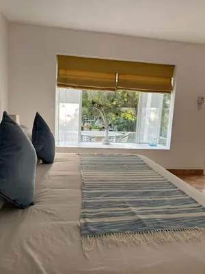 a large bed with two pillows and a window at Hotel Los Palomos in Lunahuaná