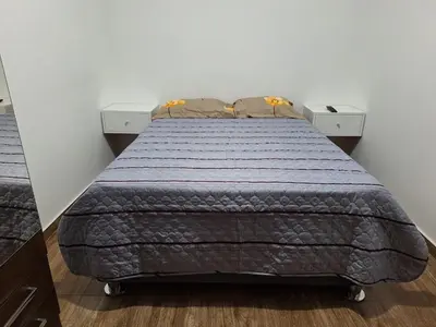 a bedroom with a bed with a blue comforter at Dormitorio matrimonial 01 in Lima
