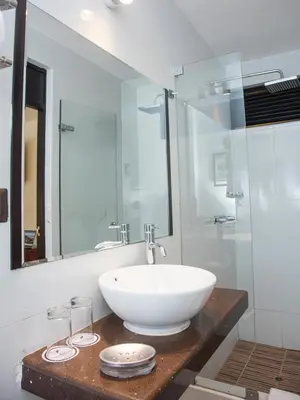 a bathroom with a white sink and a glass shower at Hotel Ferré Machu Picchu in Machu Picchu