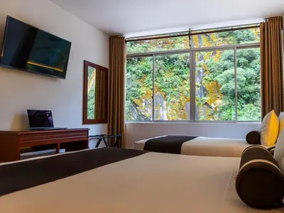 a hotel room with two beds and a large window at Hotel Ferré Machu Picchu in Machu Picchu