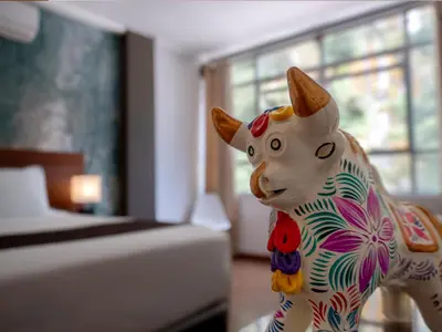 a statue of a cow in a bedroom at Hotel Ferré Machu Picchu in Machu Picchu