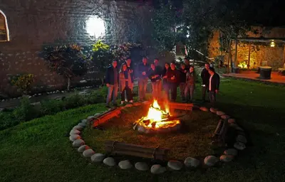 a group of people standing around a fire in a yard at La Fortaleza del Inca in Lunahuaná