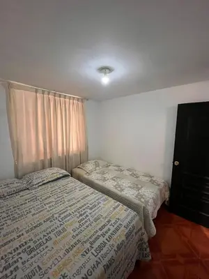 a bedroom with two beds and a window at Palmeras house in Ica