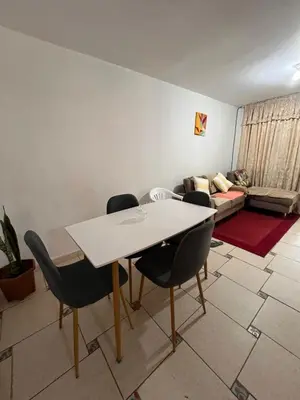 a living room with a table and chairs and a couch at Palmeras house in Ica