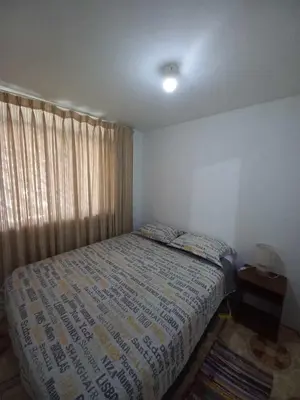 a small bedroom with a bed and a window at Palmeras house in Ica