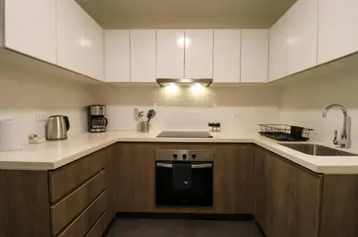 a kitchen with white cabinets and a sink and a stove at Soul by Wynwood House in Lima