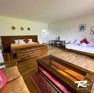 a hotel room with two beds and a couch at HOTEL RUSTICA CIENEGUILLA in Cieneguilla