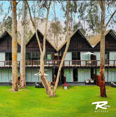a resort building with trees and a green yard at HOTEL RUSTICA CIENEGUILLA in Cieneguilla