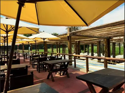 a restaurant with tables and umbrellas on a patio at HOTEL RUSTICA CIENEGUILLA in Cieneguilla