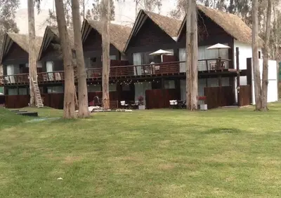 a large house with a deck with trees at HOTEL RUSTICA CIENEGUILLA in Cieneguilla