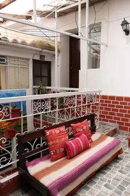 a bench with several pillows on a balcony at Millas House Cusco in Cusco