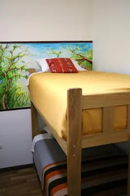 a bunk bed in a room with a painting on the wall at Millas House Cusco in Cusco
