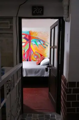 a room with a bed with a painting on the wall at Millas House Cusco in Cusco