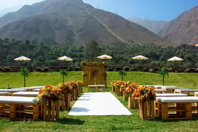 a wedding aisle with flowers in a field with mountains at HOTEL RUSTICA SANTA EULALIA in Lima