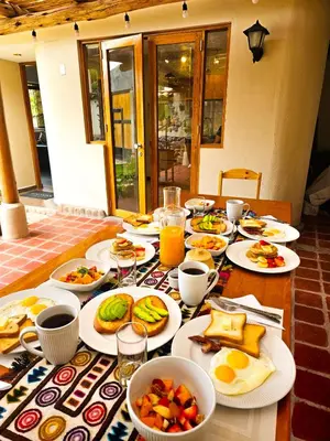 a table with plates of food on top of it at Hotel and Country House Valle Sagrado de los Incas in Huaran