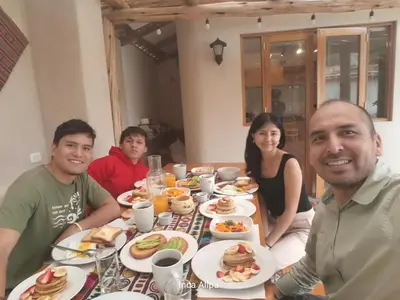 a group of people sitting around a table with food at Hotel and Country House Valle Sagrado de los Incas in Huaran