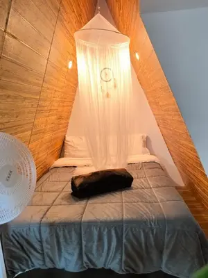 a bed in a small room with a ceiling at Vallecito Lodge in Muyurina