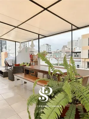 a patio with a table and a large umbrella at Casa Águila y Cóndor Miraflores in Lima