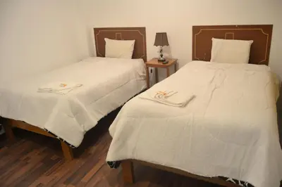 two beds sitting next to each other in a room at Apu Wasi in Cusco