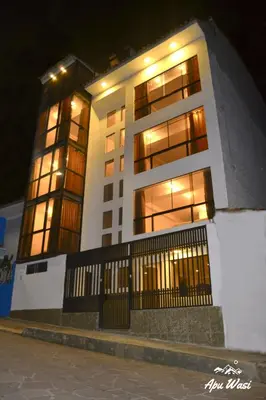 a large white building with windows at night at Apu Wasi in Cusco