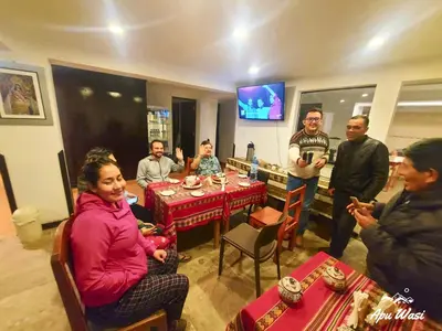 a group of people sitting around a table in a restaurant at Apu Wasi in Cusco