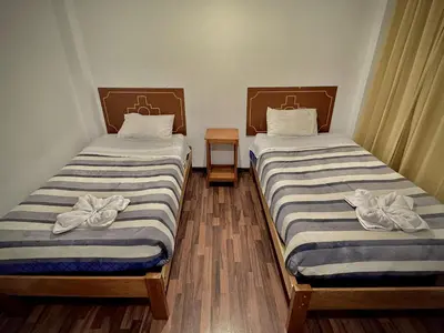 two beds in a room with towels on them at Apu Wasi in Cusco