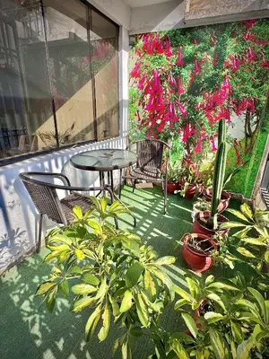 a patio with a table and chairs and potted plants at Apu Wasi in Cusco