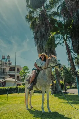 a woman riding on a horse in the grass at Hotel Fundo San Rafael in Nazca