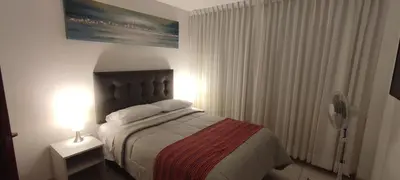 a bedroom with a bed and a lamp on a table at Sumaq AirPort in Lima